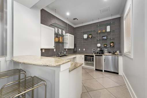 A kitchen with white cabinets and a marble countertop at The Fenwick Apartments, Humble, TX, 77396