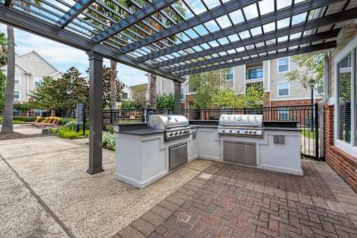 A patio with a grill and a pergola at The Fenwick Apartments, Humble