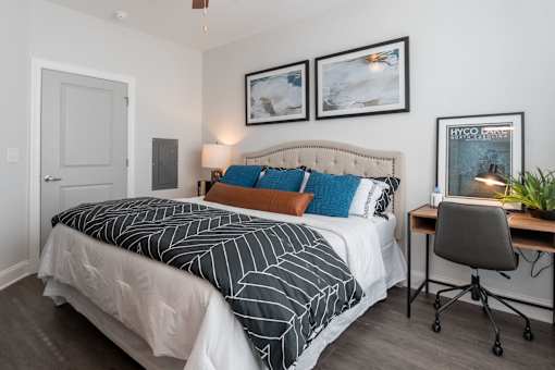 A bedroom with a bed, desk, and chair.at The One at Millington, Millington, 38053