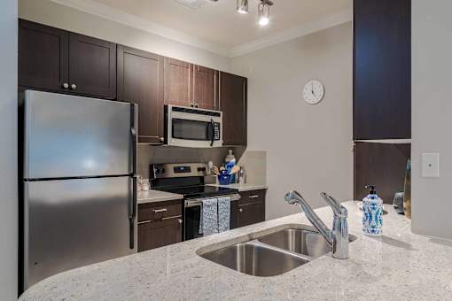 A kitchen with a stainless steel refrigerator and a microwave oven. at The Ren, Georgia, 30329