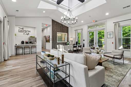 A modern living room with a white sofa and a glass coffee table.