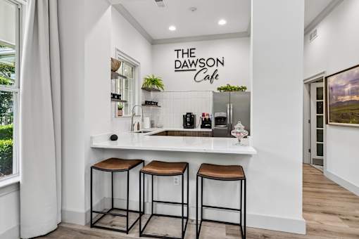 A cafe with a white counter and two stools.