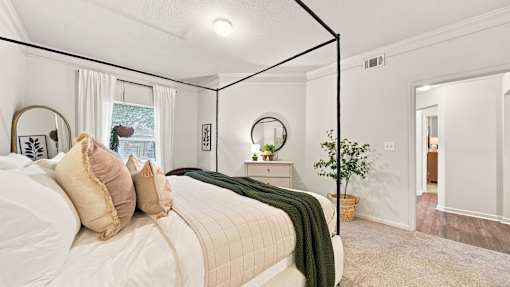 A bedroom with a large bed and a mirror on the wall.