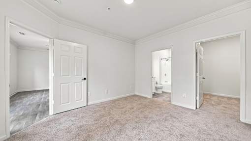 A white room with a carpeted floor and two doors.