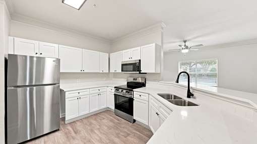 A modern kitchen with stainless steel appliances and white cabinets.