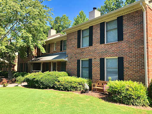 A house with a green lawn and a tree in front. at Villas on Briarcliff, Atlanta, GA
