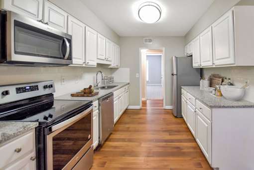 A kitchen with white cabinets and a black stove top oven. at Villas on Briarcliff, Atlanta, 30329