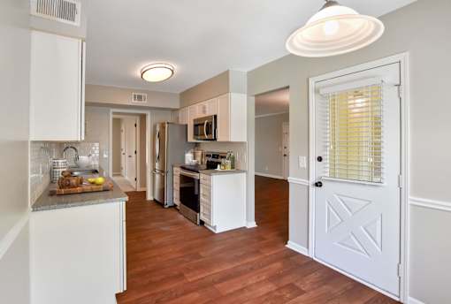 A kitchen with white cabinets and a white door. at Villas on Briarcliff, Atlanta