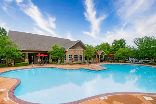 A large swimming pool in front of a house.