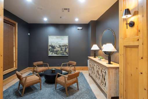 A room with a table, chairs and a painting on the wall.