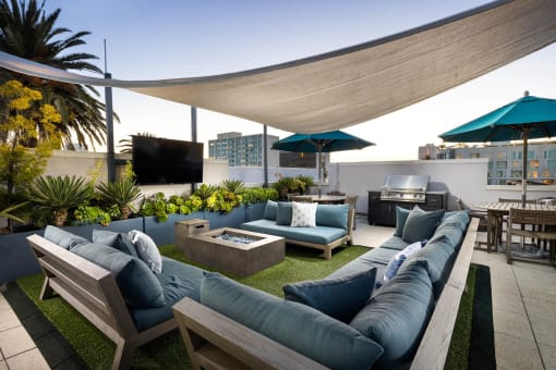 a roof terrace with couches and umbrellas