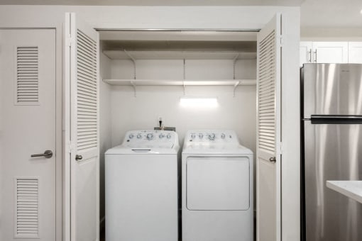 In-unit washer and dryer inside a closet with shelf storage