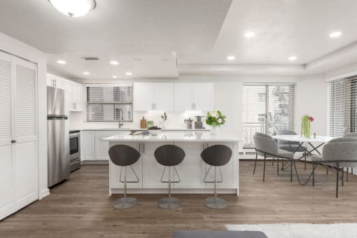 Kitchen with a kitchen island, hardwod flooring, white cabinetry, and stainless steel appliances