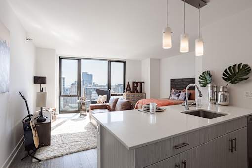 A modern kitchen with a large island and a view of the city.