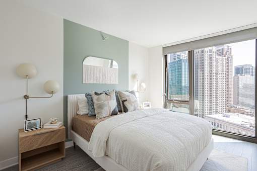 A bedroom with a large bed and a view of the city.