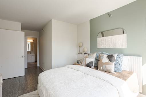 A bedroom with a large bed and a mirror above it.