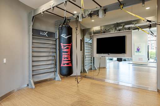 A gym with a punching bag and a television.