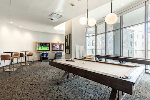 A room with a pool table and a television.