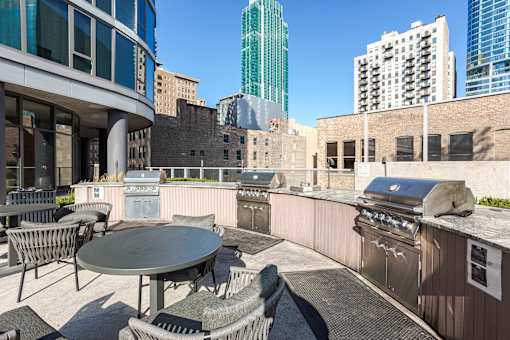 A patio with a table and chairs overlooking a cityscape.