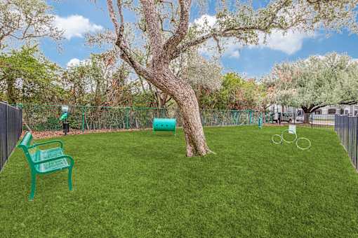 A green plastic chair sits on a green lawn.