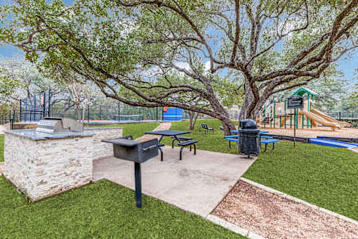 A park with a playground, picnic table, and a mailbox.