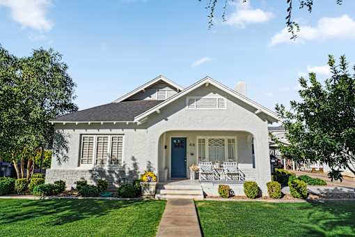 A white house with a blue door and a small porch.