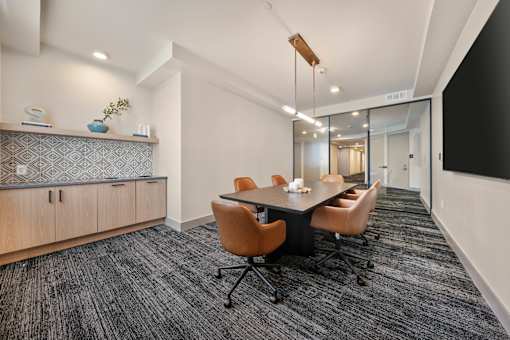 A conference room with a long table and chairs.