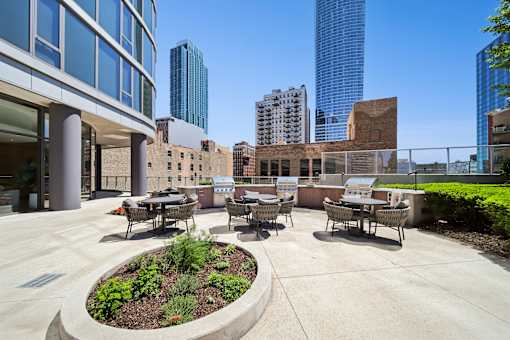 Outdoor grilling station and resident patio at a South Loop Chicago apartment community with city skyline views.