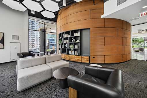 A modern office space with a curved wooden wall and a white sofa.