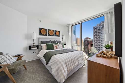 Contemporary bedroom with large windows and skyline views in South Loop Chicago apartment