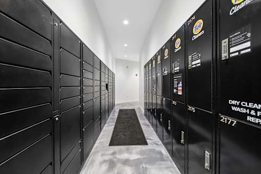 A long hallway of black dry cleaning machines.