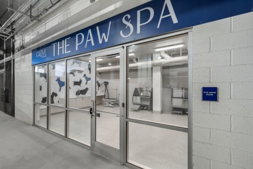 the pav spa entrance with glass doors and a blue sign on the wall