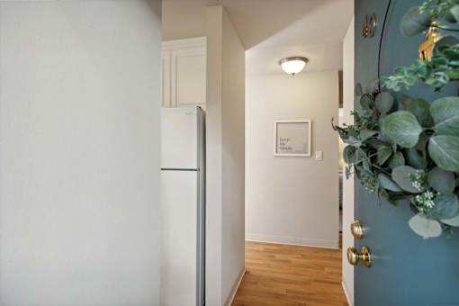A hallway with a white door and a blue wall.