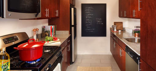 a kitchen with a pot on the stove and a blackboard on the wall