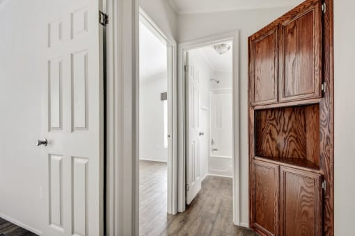 a hallway with a wooden cabinet and a white door