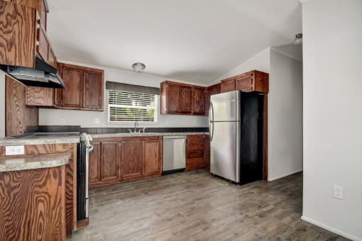 a kitchen with wooden cabinets and a black refrigerator