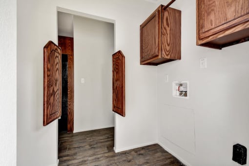 a room with white walls and wooden cabinets