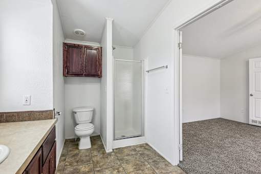 A bathroom with a toilet, sink, and shower.