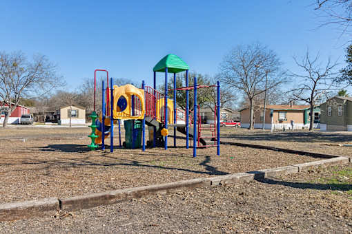 A playground with a yellow slide and a green roof.