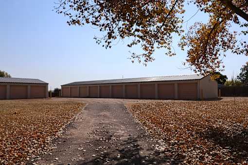 a building with a gravel road in front of it and a tree at Circle Park, Wyoming