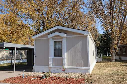 a tiny house on the side of a yard with trees 82007