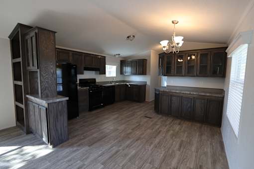 an empty kitchen with black appliances and wooden cabinets at Circle Park, Wyoming