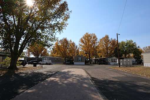 a parking lot with houses and trees on a sunny day at Circle Park, Cheyenne, Wyoming