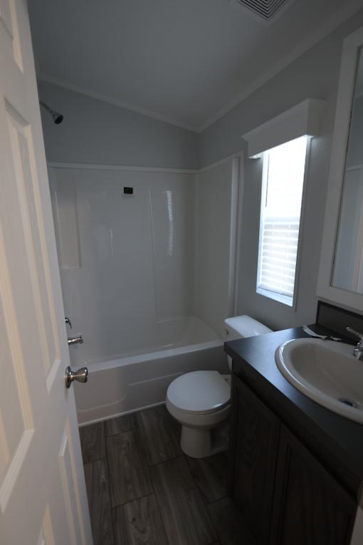 a small bathroom with a toilet and a sink at Horizon MHC, Rock Springs, WY