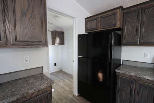a kitchen with a black refrigerator and wooden cabinets at Up House, Connecticut