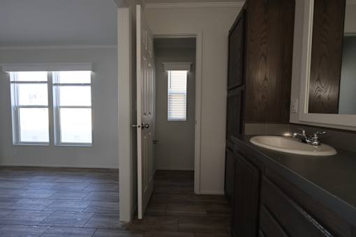 an empty bathroom with a sink and a door to a hallway at Horizon MHC, Rock Springs, WY