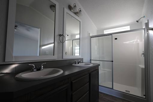 a bathroom with two sinks and a shower at Horizon MHC, Rock Springs, WY 82901
