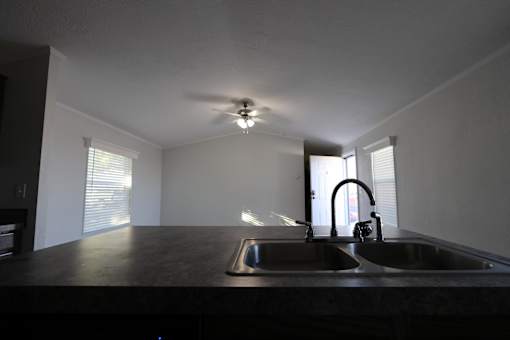 an empty kitchen with a sink and a ceiling fan at Up House, Connecticut