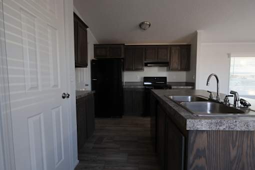 a kitchen with wooden cabinets and a sink at Horizon MHC, Wyoming