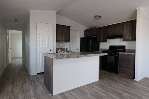 an empty kitchen with an island in the middle of it at Horizon MHC, Wyoming